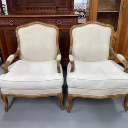 Pair of vintage Louis 15th style oak framed bergeres chairs with good size seats. making them very comfortable to sit in. The upholstery is in used condition with stains as shown in photos. Overall the timber frames are strong &amp; solid. They have been sourced directly from France. 