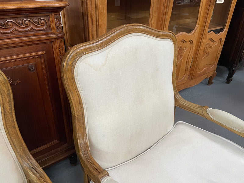 Pair of vintage Louis 15th style oak framed bergeres chairs with good size seats. making them very comfortable to sit in. The upholstery is in used condition with stains as shown in photos. Overall the timber frames are strong &amp; solid. They have been sourced directly from France. 