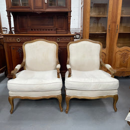 Pair of vintage Louis 15th style oak framed bergeres chairs with good size seats. making them very comfortable to sit in. The upholstery is in used condition with stains as shown in photos. Overall the timber frames are strong &amp; solid. They have been sourced directly from France. 