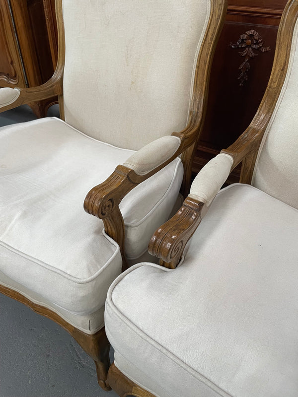 Pair of vintage Louis 15th style oak framed bergeres chairs with good size seats. making them very comfortable to sit in. The upholstery is in used condition with stains as shown in photos. Overall the timber frames are strong &amp; solid. They have been sourced directly from France. 