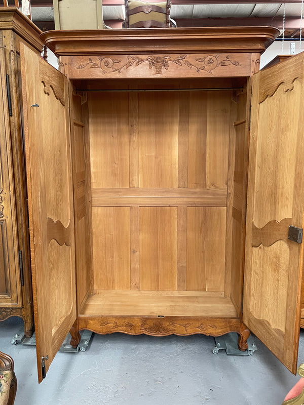 This attractive two door armoire has full hanging space. It is a pleasing piece with fine decorative carvings on the doors and is known as a marriage armoire. Imported directly from France and is in good original detailed condition.