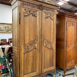 Attractive French Oak two door decoratively carved armoire with hanging space and adjustable/removable shelves. Imported directly from France and is in good original detailed condition. 