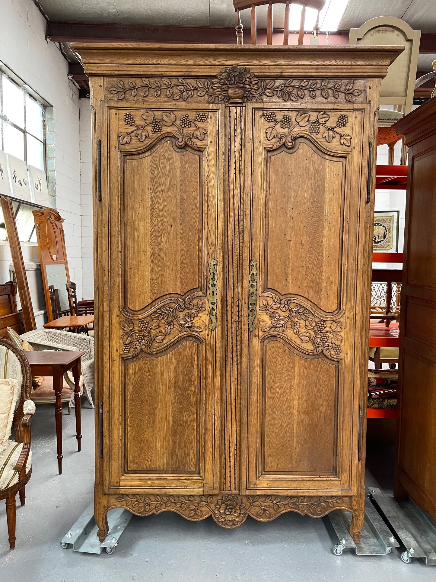 Attractive French Oak two door decoratively carved armoire with hanging space and adjustable/removable shelves. Imported directly from France and is in good original detailed condition. 