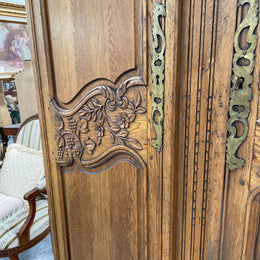 Attractive French Oak two door decoratively carved armoire with hanging space and adjustable/removable shelves. Imported directly from France and is in good original detailed condition. 