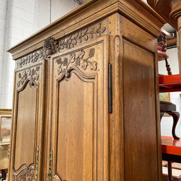Attractive French Oak two door decoratively carved armoire with hanging space and adjustable/removable shelves. Imported directly from France and is in good original detailed condition. 