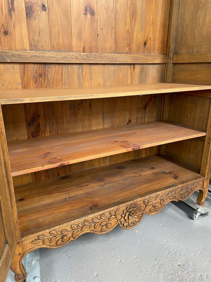 Attractive French Oak two door decoratively carved armoire with hanging space and adjustable/removable shelves. Imported directly from France and is in good original detailed condition. 