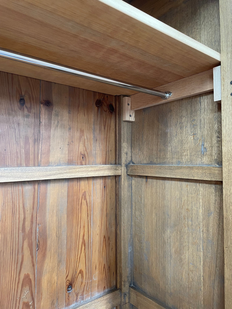 Attractive French Oak two door decoratively carved armoire with hanging space and adjustable/removable shelves. Imported directly from France and is in good original detailed condition. 