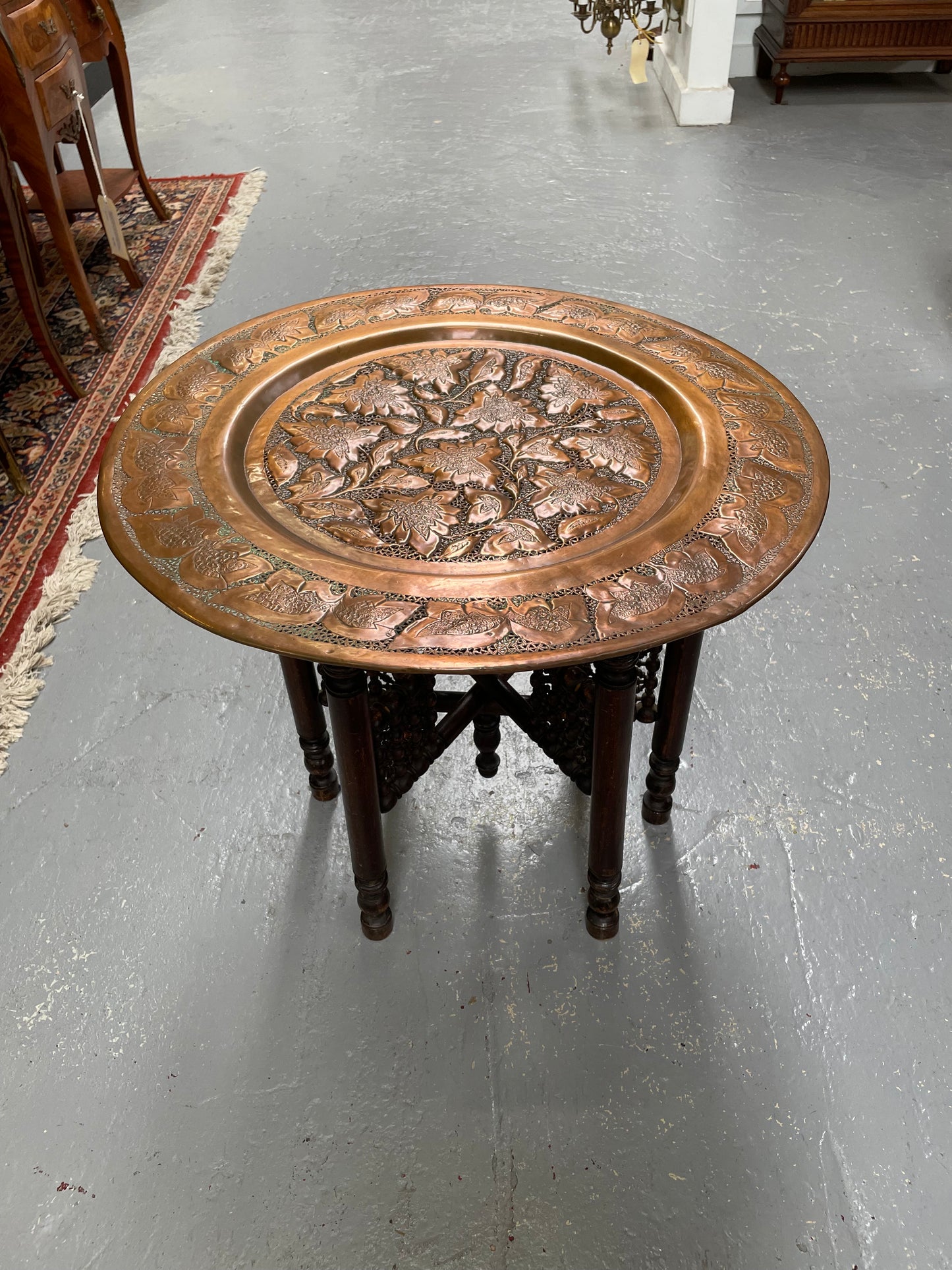 Middle eastern carved folding bases coffee table. It has a copper top intricately pierced and patterned. It is in good original condition. Please see photos as they form part of the description and condition.