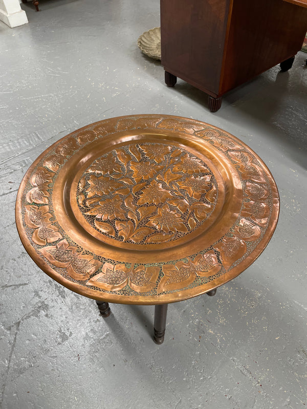 Middle eastern carved folding bases coffee table. It has a copper top intricately pierced and patterned. It is in good original condition. Please see photos as they form part of the description and condition.