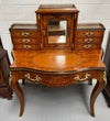 A very attractive burr walnut writing desk (Bonheur De Jour) with ormolu mounts throughout. The boxwood inlaid decoration is featured on the drawers and the mirrored cupboard which also feature brass galleries. The table area features burr walnut and a tooled leather inlay. A long drawer underneath features further inlay and stringing and all have lovely ormolu handles. It is a stunning piece of furniture of fantastic quality and makes a good ladies writing desk. In very good condition.