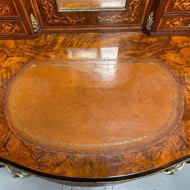 A very attractive burr walnut writing desk (Bonheur De Jour) with ormolu mounts throughout. The boxwood inlaid decoration is featured on the drawers and the mirrored cupboard which also feature brass galleries. The table area features burr walnut and a tooled leather inlay. A long drawer underneath features further inlay and stringing and all have lovely ormolu handles. It is a stunning piece of furniture of fantastic quality and makes a good ladies writing desk. In very good condition.