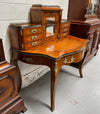 A very attractive burr walnut writing desk (Bonheur De Jour) with ormolu mounts throughout. The boxwood inlaid decoration is featured on the drawers and the mirrored cupboard which also feature brass galleries. The table area features burr walnut and a tooled leather inlay. A long drawer underneath features further inlay and stringing and all have lovely ormolu handles. It is a stunning piece of furniture of fantastic quality and makes a good ladies writing desk. In very good condition.