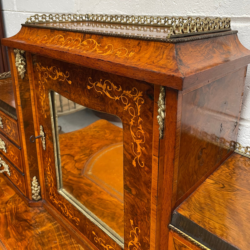 A very attractive burr walnut writing desk (Bonheur De Jour) with ormolu mounts throughout. The boxwood inlaid decoration is featured on the drawers and the mirrored cupboard which also feature brass galleries. The table area features burr walnut and a tooled leather inlay. A long drawer underneath features further inlay and stringing and all have lovely ormolu handles. It is a stunning piece of furniture of fantastic quality and makes a good ladies writing desk. In very good condition.