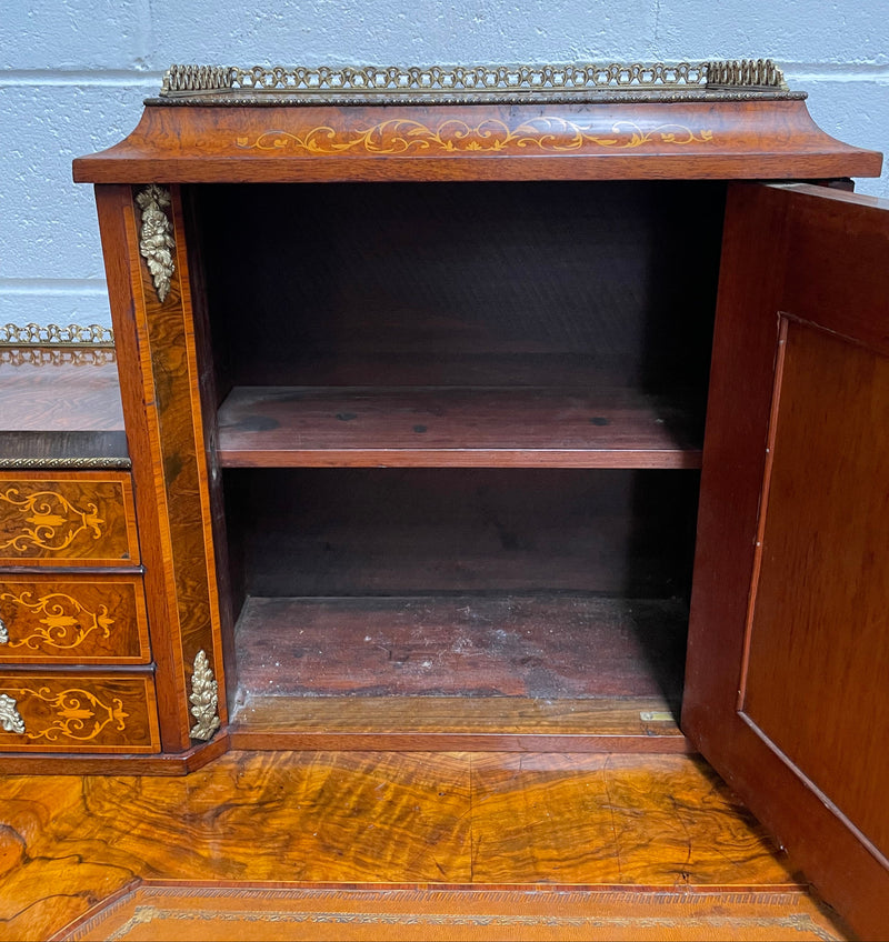 A very attractive burr walnut writing desk (Bonheur De Jour) with ormolu mounts throughout. The boxwood inlaid decoration is featured on the drawers and the mirrored cupboard which also feature brass galleries. The table area features burr walnut and a tooled leather inlay. A long drawer underneath features further inlay and stringing and all have lovely ormolu handles. It is a stunning piece of furniture of fantastic quality and makes a good ladies writing desk. In very good condition.