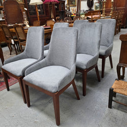 Grey fabric dining chairs with walnut-toned timber frames