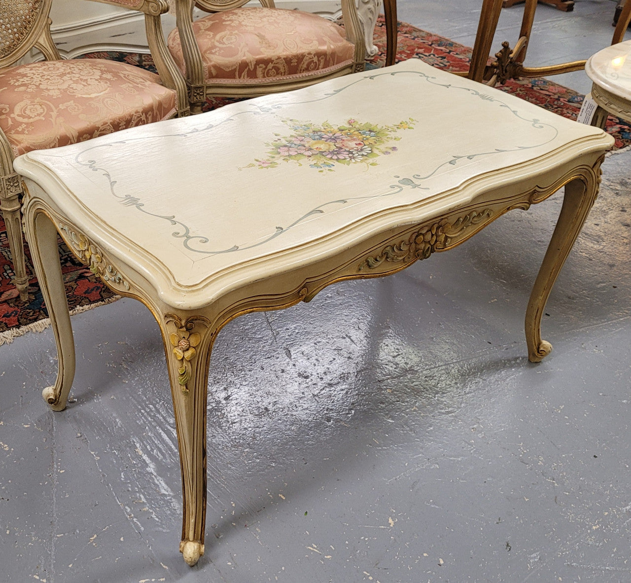 Delightful Vintage French Louis 15th style coffee table with original painted floral centerpiece and gilded highlights. It has been sourced from France and are in good original condition.