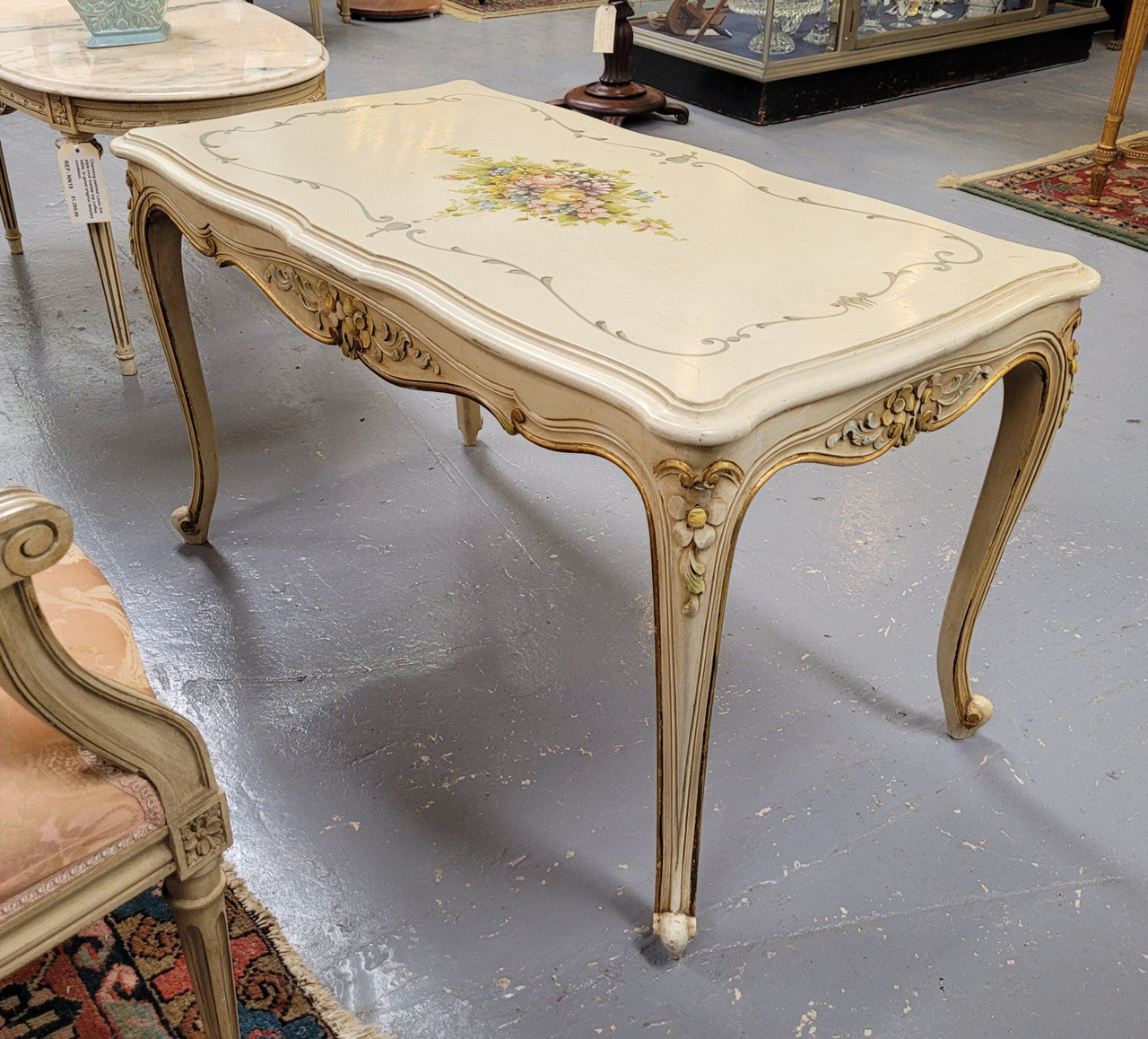 Delightful Vintage French Louis 15th style coffee table with original painted floral centerpiece and gilded highlights. It has been sourced from France and are in good original condition.