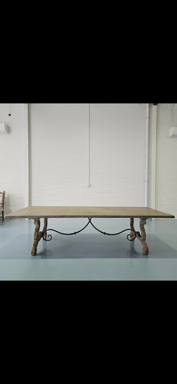 Large French style dining table with carved legs and wrought iron stretcher