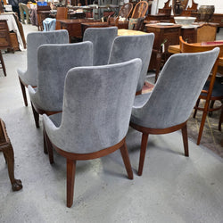 Modern grey dining chairs showing curved upholstered backs