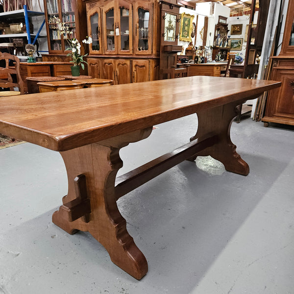 Stunning French oak monastery dining table. The top is supported on a large trestle base, and united with a single stretcher secured at each end with oak pegs. Sourced directly from France and is in good restored condition. It can seat 6-8 people comfortably.