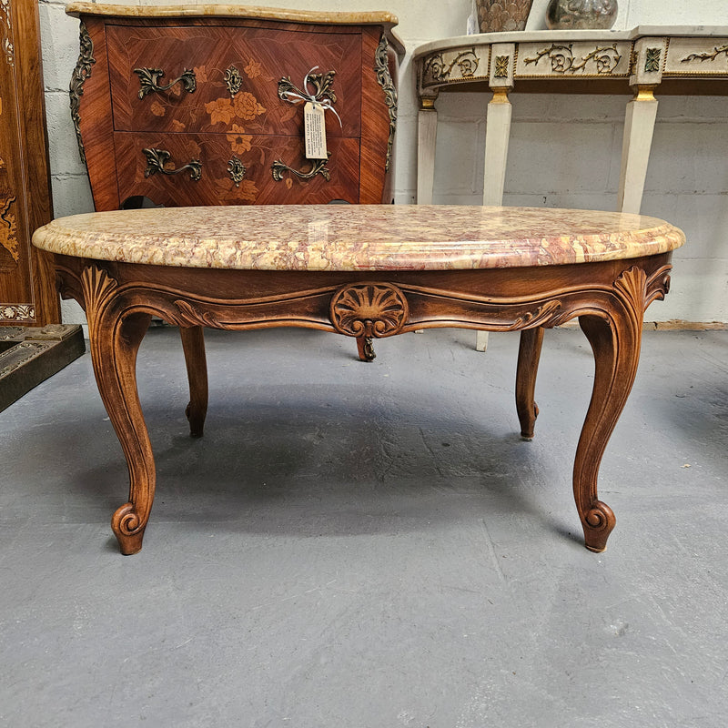 Lovely Louis XV style French fruitwood oval coffee table with a beautiful marble top. This piece is in great original condition and have been detailed to maintain its original condition.