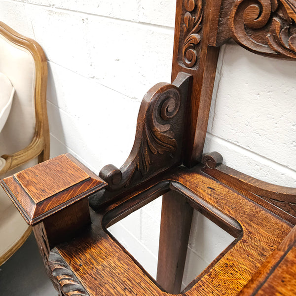 Stunning English Oak gothic style hallstand with one drawer, mirror and 6 hooks and two compartments for umbrellas. It is beautifully decorated and carved. It is in good original detailed condition. 