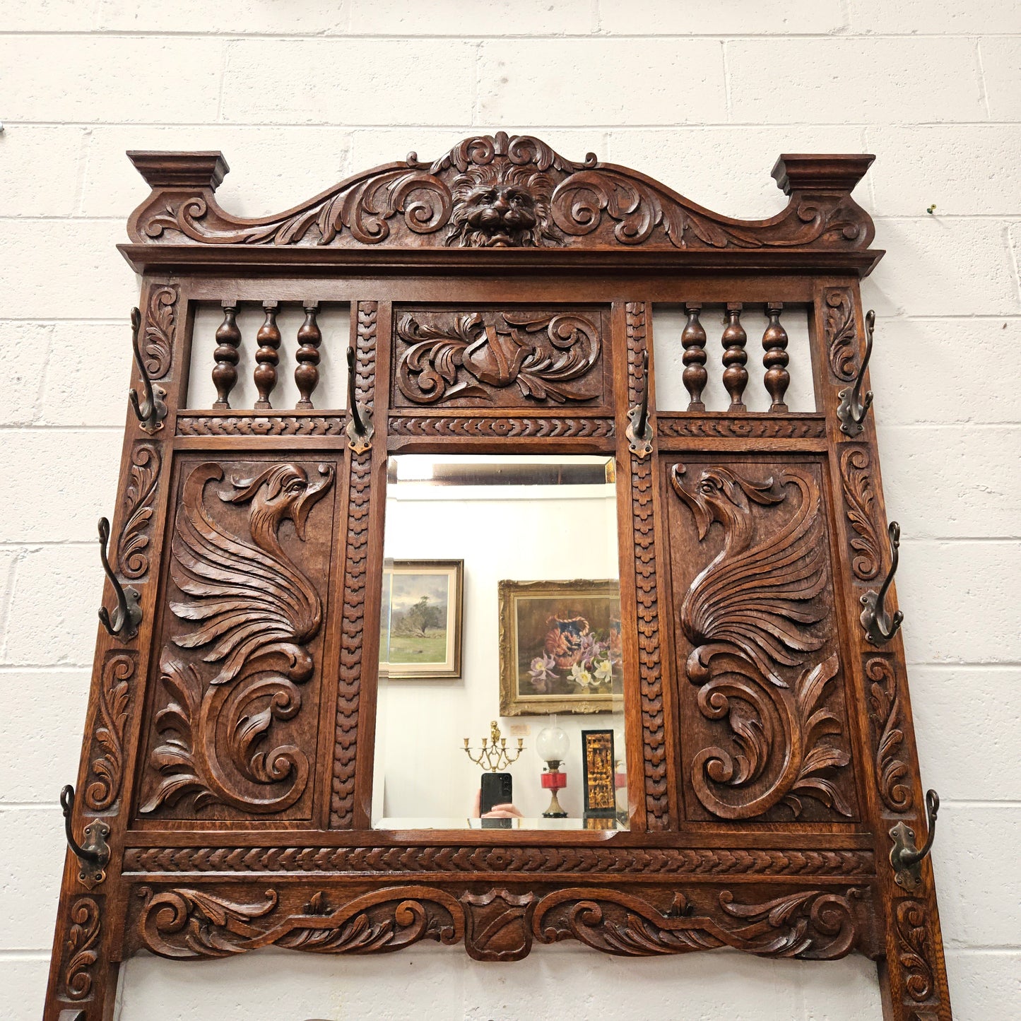 Stunning English Oak gothic style hallstand with one drawer, mirror and 6 hooks and two compartments for umbrellas. It is beautifully decorated and carved. It is in good original detailed condition. 