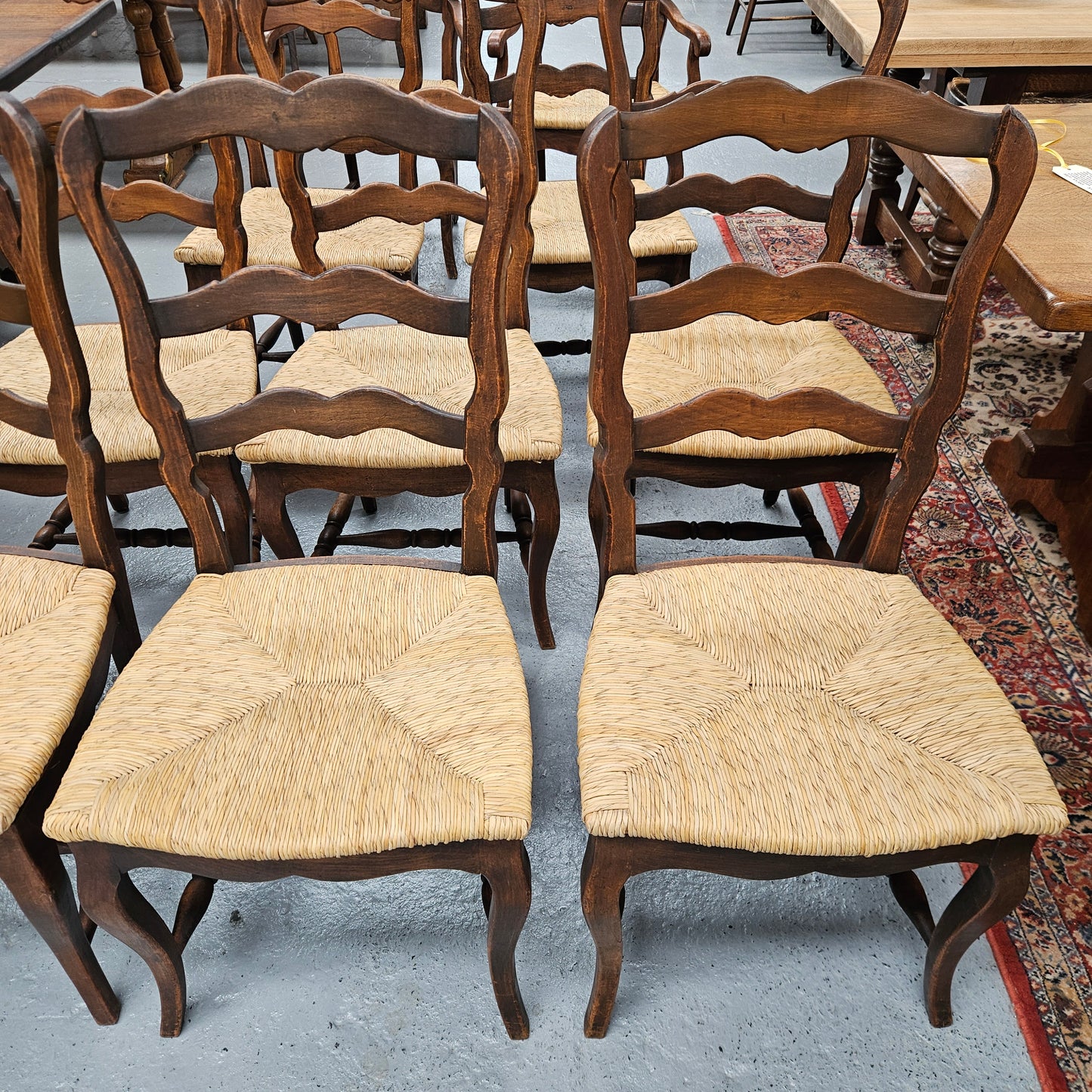 Set of ten French oak rush seats with eight dining chairs and two carvers. They have a comfortable wide rush seat and are in good original condition.