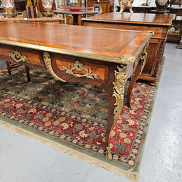An exceptional French 19th Century Louis XV style "Bureau Plat" tooled leather top desk. Made from kingwood and rosewood, It has superb gilt cast ormolu mounts all the way around which means it can be used floating in the center of a room. In very good restored condition.