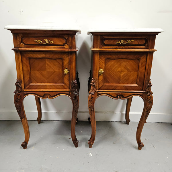 Pair of French Walnut Louis XV Style white marble top bedside cabinets. Featuring beautiful parquetry work and decorative carvings throughout. Sourced directly from France and in good original detailed condition.