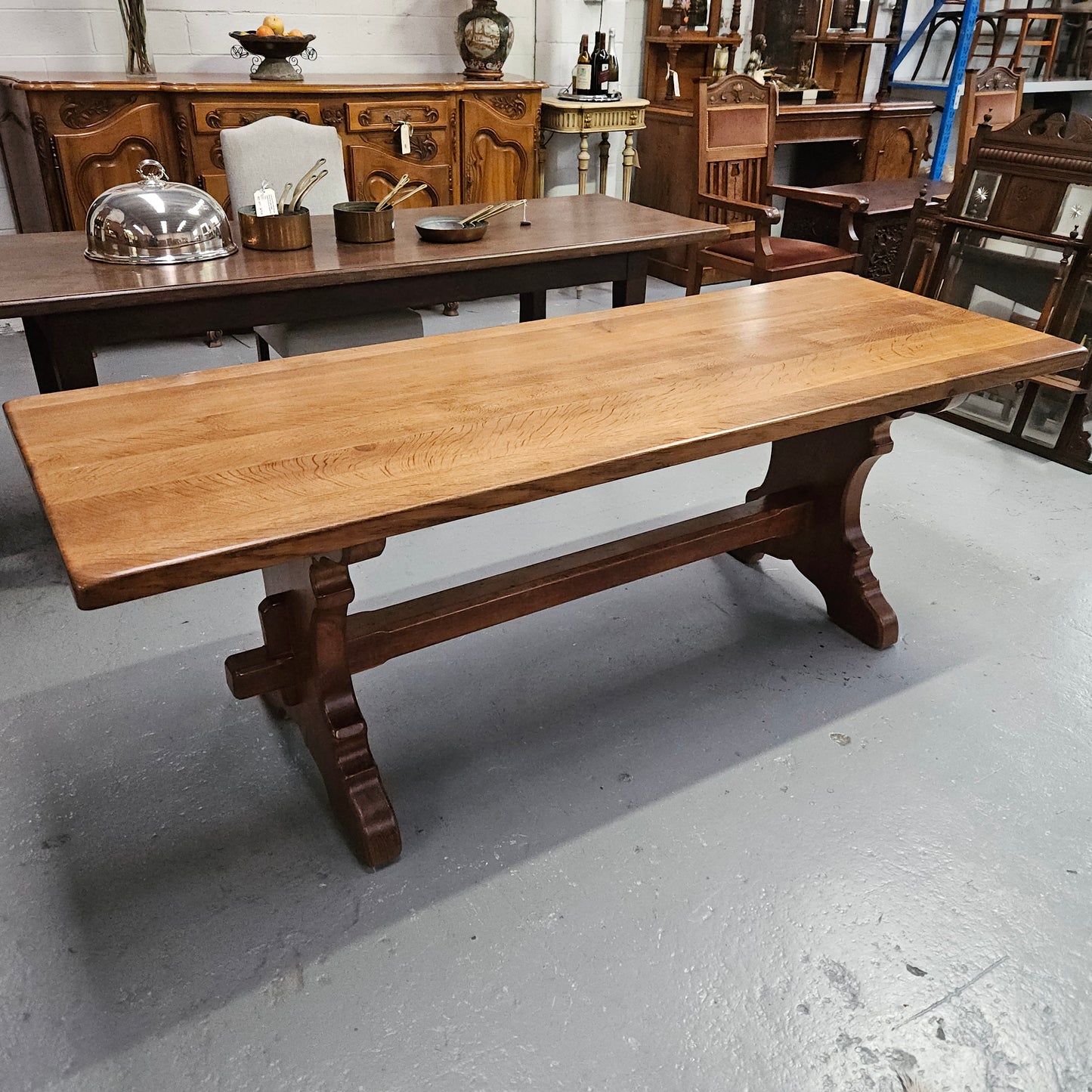 Stunning French oak monastery dining table. The top is supported on a large trestle base, and united with a single stretcher secured at each end with oak pegs. Sourced directly from France and is in good restored condition. It can seat 6-8 people comfortably.