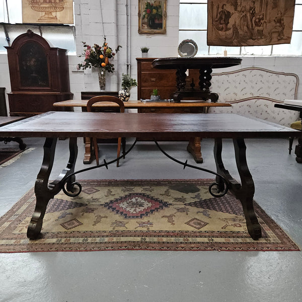 Vintage walnut Spanish style farmhouse table with a beautiful top and iron work. It is in good restored condition. Circa 1950'S.