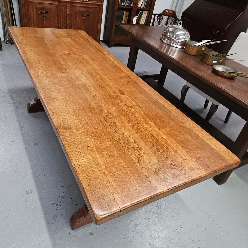 Stunning French oak monastery dining table. The top is supported on a large trestle base, and united with a single stretcher secured at each end with oak pegs. Sourced directly from France and is in good restored condition. It can seat 6-8 people comfortably.