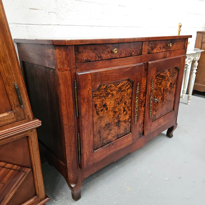 Stunning early 19th Century Elm buffet featuring two highly figured elm doors and drawers, it provides ample storage and is in good original condition.