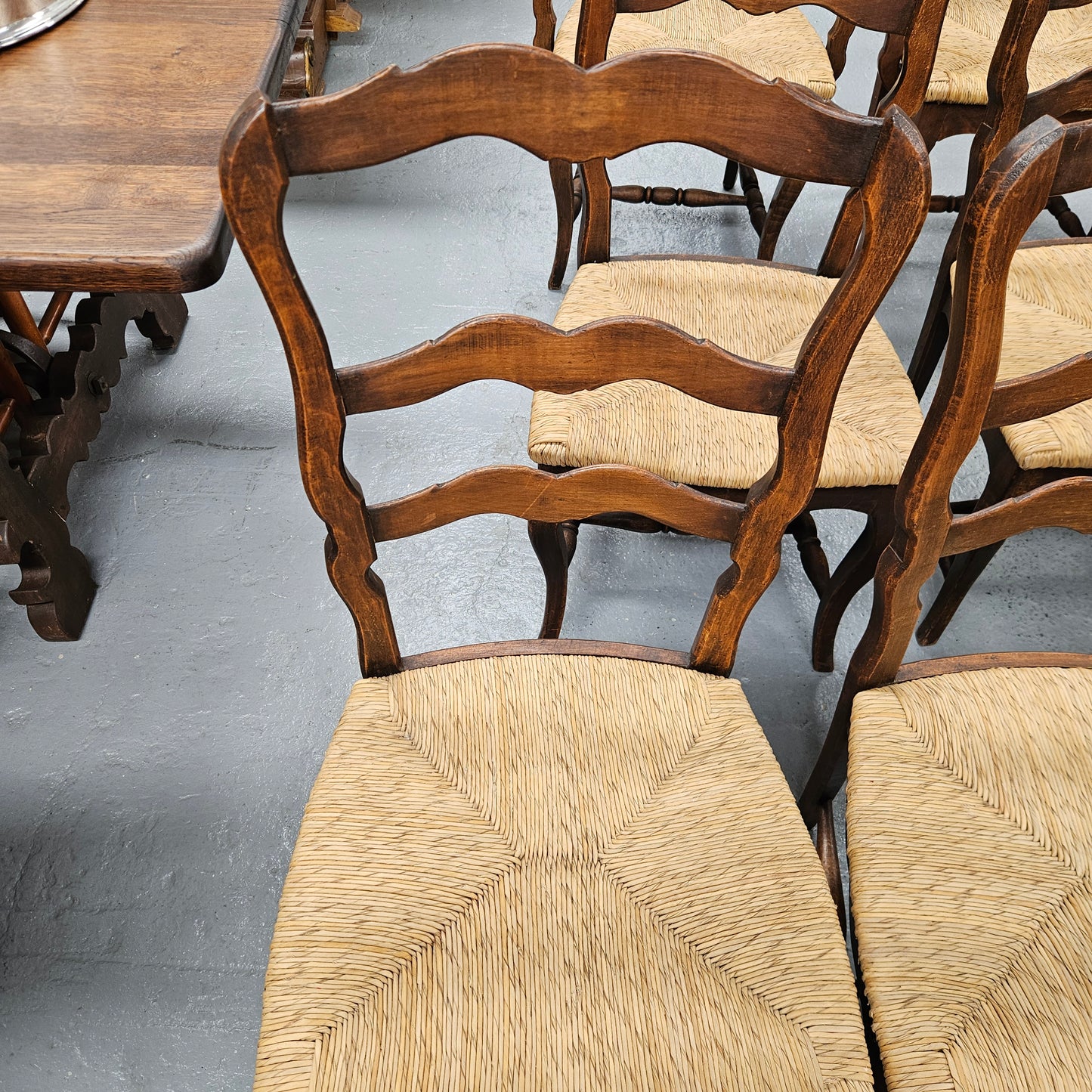 Set of ten French oak rush seats with eight dining chairs and two carvers. They have a comfortable wide rush seat and are in good original condition.