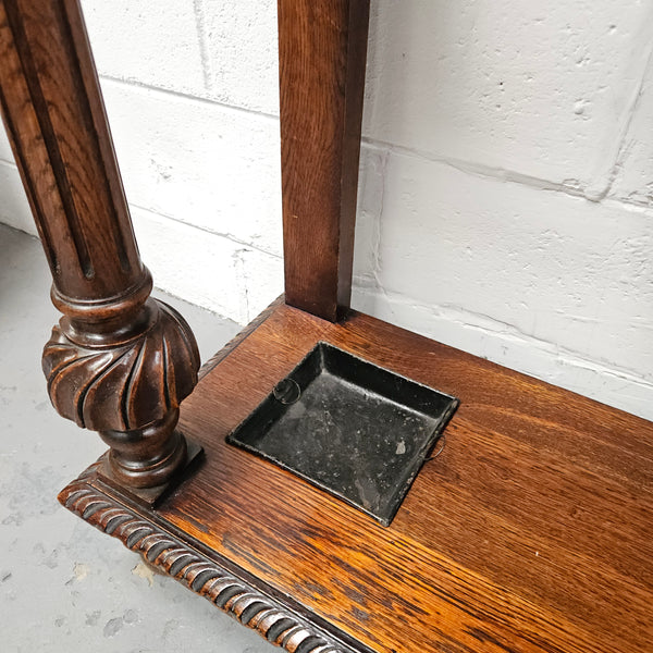 Stunning English Oak gothic style hallstand with one drawer, mirror and 6 hooks and two compartments for umbrellas. It is beautifully decorated and carved. It is in good original detailed condition. 