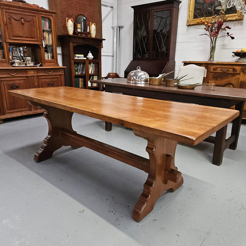 Stunning French oak monastery dining table. The top is supported on a large trestle base, and united with a single stretcher secured at each end with oak pegs. Sourced directly from France and is in good restored condition. It can seat 6-8 people comfortably.