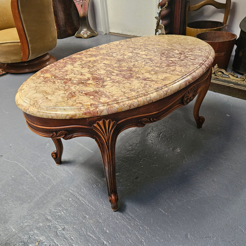 Lovely Louis XV style French fruitwood oval coffee table with a beautiful marble top. This piece is in great original condition and has been detailed to maintain its original condition.