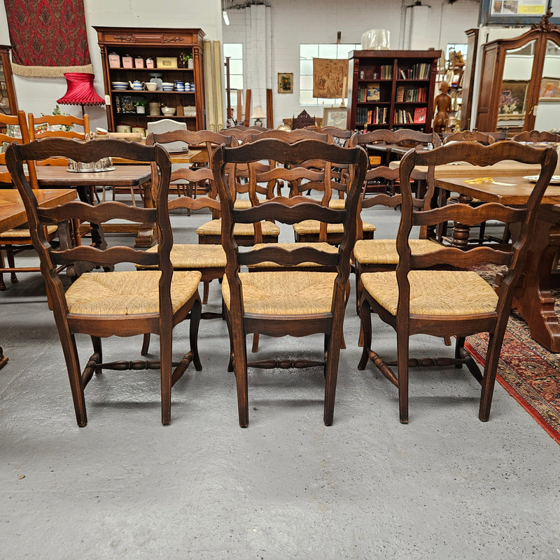 Set of ten French oak rush seats with eight dining chairs and two carvers. They have a comfortable wide rush seat and are in good original condition.