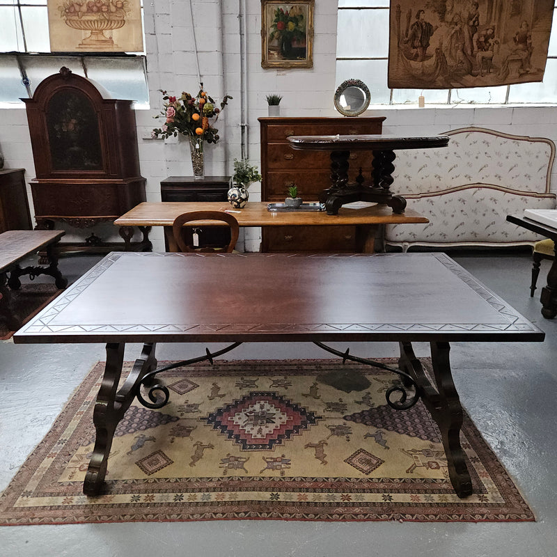 Vintage walnut Spanish style farmhouse table with a beautiful top and iron work. It is in good restored condition. Circa 1950'S.