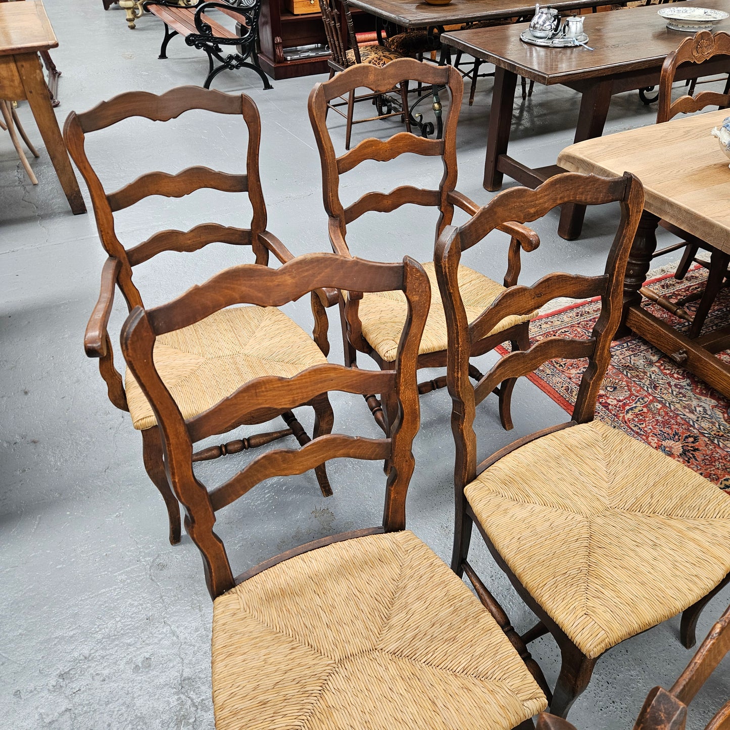 Set of ten French oak rush seats with eight dining chairs and two carvers. They have a comfortable wide rush seat and are in good original condition.