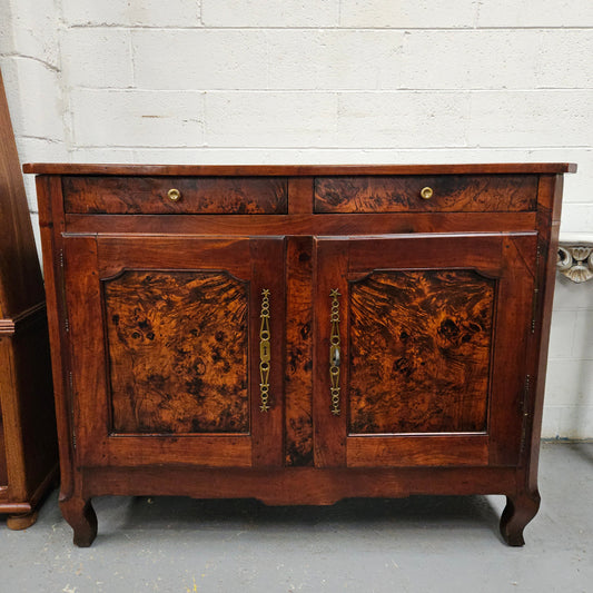 Stunning early 19th Century Elm buffet featuring two highly figured elm doors and drawers, it provides ample storage and is in good original condition.