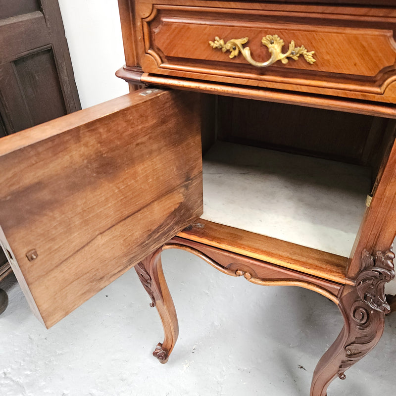 Pair of French Walnut Louis XV Style white marble top bedside cabinets. Featuring beautiful parquetry work and decorative carvings throughout. Sourced directly from France and in good original detailed condition.