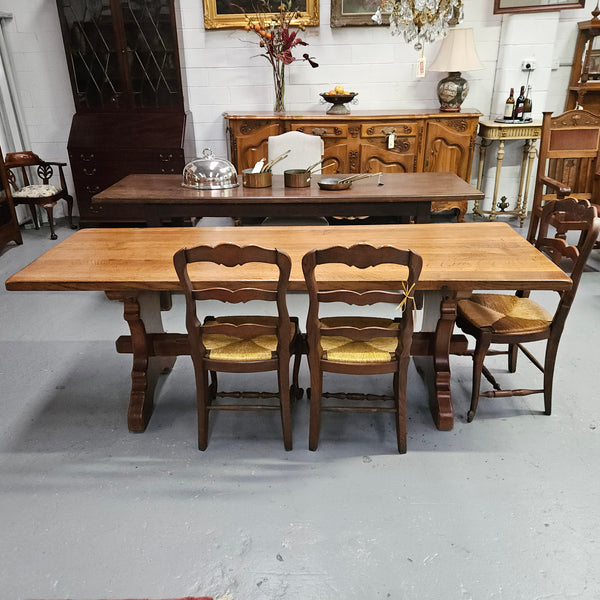 Stunning French oak monastery dining table. The top is supported on a large trestle base, and united with a single stretcher secured at each end with oak pegs. Sourced directly from France and is in good restored condition. It can seat 6-8 people comfortably.