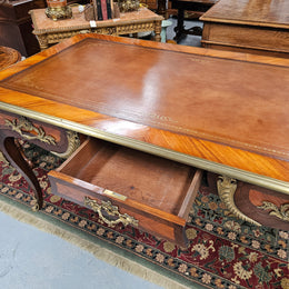 An exceptional French 19th Century Louis XV style "Bureau Plat" tooled leather top desk. Made from kingwood and rosewood, It has superb gilt cast ormolu mounts all the way around which means it can be used floating in the center of a room. In very good restored condition.