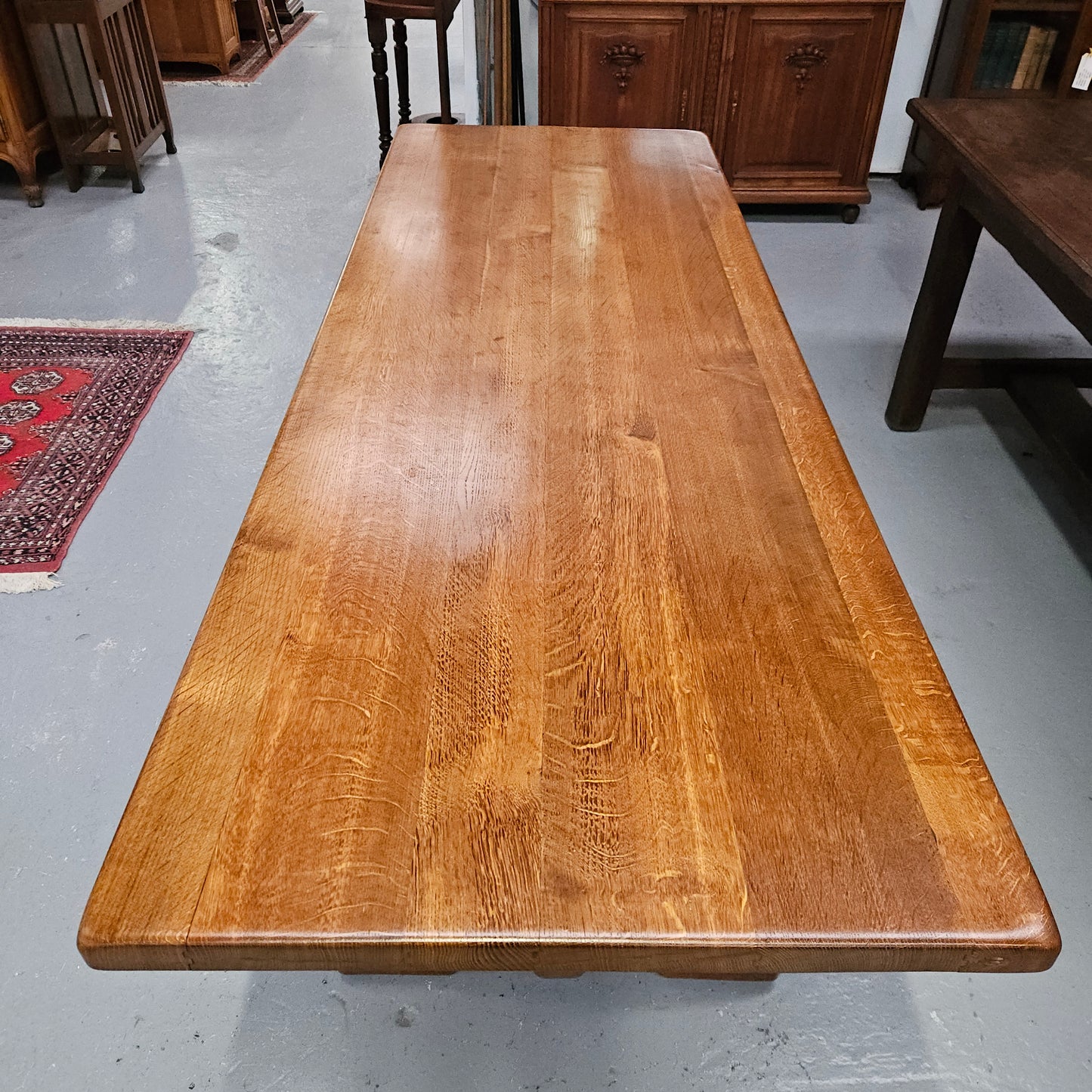 Stunning French oak monastery dining table. The top is supported on a large trestle base, and united with a single stretcher secured at each end with oak pegs. Sourced directly from France and is in good restored condition. It can seat 6-8 people comfortably.