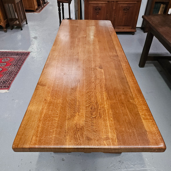 Stunning French oak monastery dining table. The top is supported on a large trestle base, and united with a single stretcher secured at each end with oak pegs. Sourced directly from France and is in good restored condition. It can seat 6-8 people comfortably.