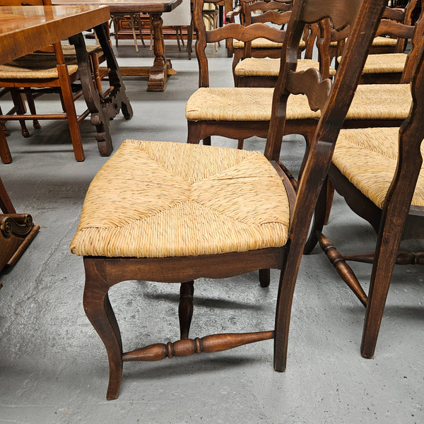 Set of ten French oak rush seats with eight dining chairs and two carvers. They have a comfortable wide rush seat and are in good original condition.