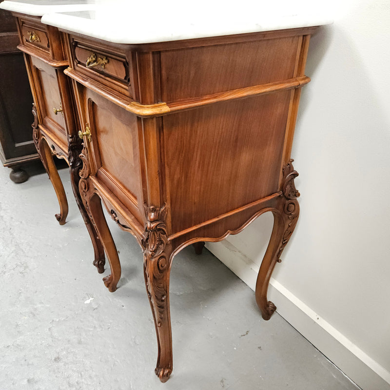 Pair of French Walnut Louis XV Style white marble top bedside cabinets. Featuring beautiful parquetry work and decorative carvings throughout. Sourced directly from France and in good original detailed condition.