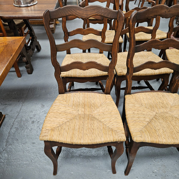 Set of ten French oak rush seats with eight dining chairs and two carvers. They have a comfortable wide rush seat and are in good original condition.